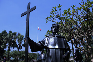 Life-size statues of Filipino priest holding cross  at Plaza Moriones inside Fort Santiago.