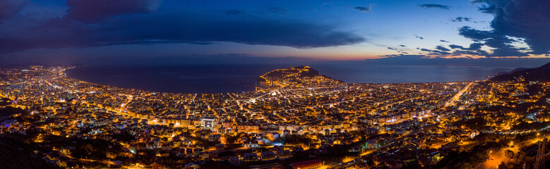 Aerial Panoramic night view of Alanya City - Alanya Castle & Peninsula in the center of the frame, Beautiful Sky, City lights and endless Mediterranean Sea