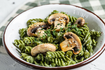 Mushroom and Spinach Pasta in a Bowl, Vegan Food on light background. Vegan or gluten free diet. banner, menu recipe place for text, top view