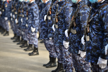 Soldiers in camouflage uniforms are seen in formation during military ceremony