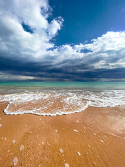 Sunny tropical beach with dramatic sky and fine golden sands. 