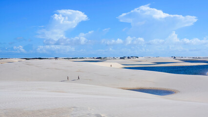 People are enjoying their free time walking in the dunes and lagunes of national park Lencois Maranhenses in Brazil