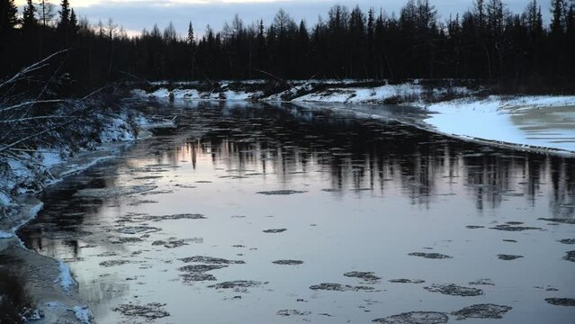Ice floats, moves along the river, ice drift, winter landscape, river in the forest