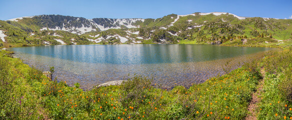 Panoramic view of a picturesque mountain lake, Altai. Sunny summer day. Traveling in the mountains, summer vacation.
