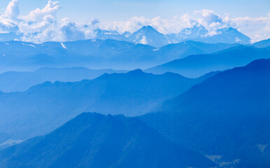 Fototapeta na wymiar Mountains in blue haze. Morning light, valley and mountainsides.