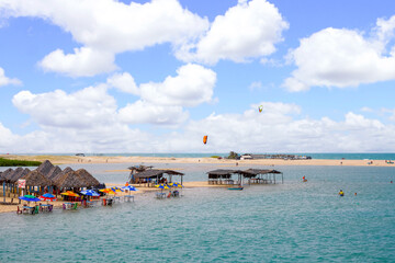 Beach bar and Kitesurfer on a lagoon with dunes in Brazil
