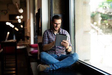 Young businessman using digital tablet in the office. Handsome man learning online.