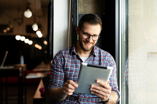 Young businessman using digital tablet in the office. Handsome man learning online.