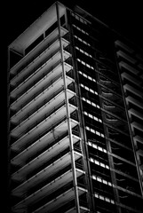 Black and white image of an unfinished multistory building in a low key. Unfinished building view at night.
