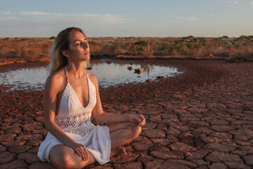 Fototapeta na wymiar beautiful young girl meditating outdoors in the desert
