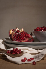 Delicious ripe pomegranate kernels in ceramic bowl on kitchen countertop. Space for text