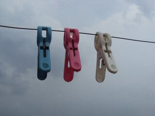 colorful cloth clips hanging from rusty iron wire