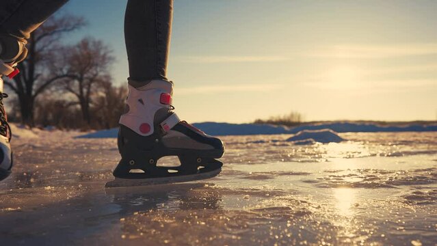 skate on the river. child playing on the river in winter. close-up legs child skating on ice in winter on the river nature. happy family kid dream concept. figure skating in winter lifestyle
