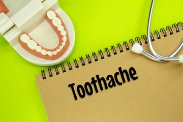 stethoscopes, human tooth models and notebooks with the word toothache