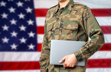 Cropped shot of a soldier computer programmer with USA flag in the background and copy space