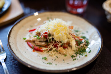 Fresh salad with chicken, vegetables and grated cheese on plate