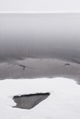 Fototapeta na wymiar Snow fall in front of frozen lake