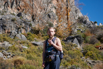 A beautiful shot of a hiking man eating in the mountains