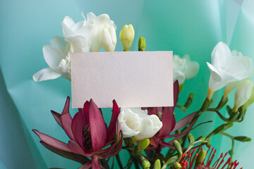 card mockup with exotic bouquet of flowers. Leukadendron red and leukospermum, freesia