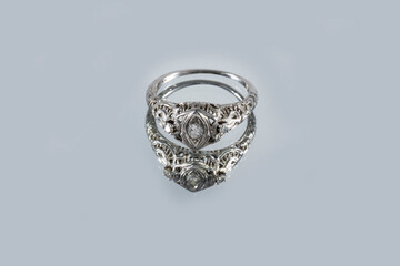 Vintage French white gold ring with natural diamonds with reflection on a gray background, art Deco style