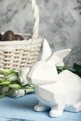 A beautiful picture with a white Easter Bunny. Basket with chocolate eggs. Holy holiday
