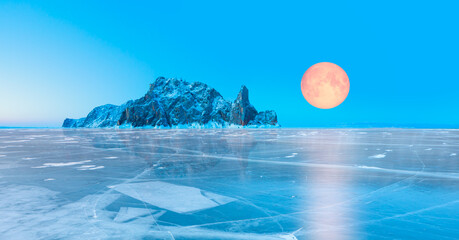 Ogoy island on winter Baikal lake with transparent cracked blue ice with full moon - Baikal,...