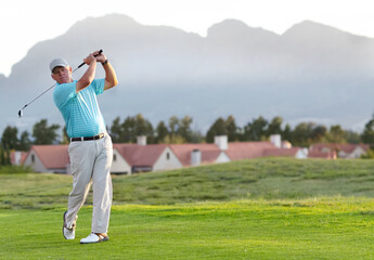 Perfect form and follow through. A male golfer admiring the shot he has just played.