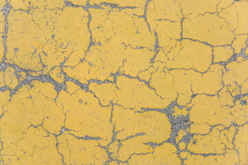 Cracks on yellow paint concrete surface cracked weathered cement worn texture broken abstract damaged pattern background