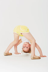 Its an upside-down world. Studio portrait of an adorable little girl bending double and looking at...