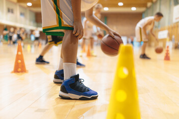 Young basketball players bounce balls on training session. School of basketball for kids. Children in basketall sport clothing improving skills