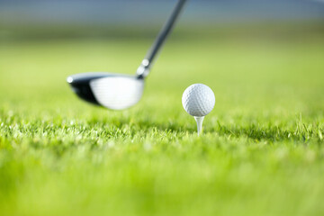 The first drive is vital. A golf club about to tee-off with a white ball on a golf course.