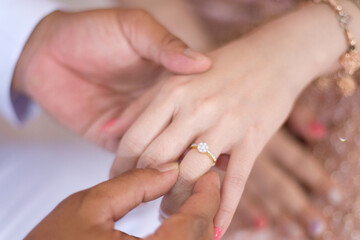 groom wears ring on bride's finger in wedding ceremony.wearing a ring at a wedding.feeling of love	
