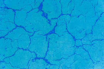 Cracks on blue paint concrete surface cracked weathered cement worn texture broken abstract damaged pattern background