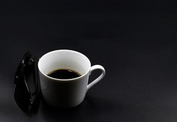 Cup of coffee next to sunglasses