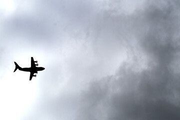 Fototapeta na wymiar Cargo plane taking off or landing under cloud covered sky