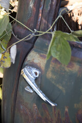 Old abandoned car rusty, pitted door handle