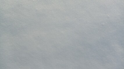 Beautiful sunny bright texture of snow in winter season. Background with natural snow texture, close-up view from above.