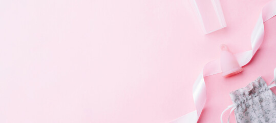 Menstrual period use cup. Pink ribbon with menstrual cup. Menstruation feminine period. Women health concept. Zero waste banner. Top view.