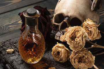 Magic potion and dry rose flowers close up background.