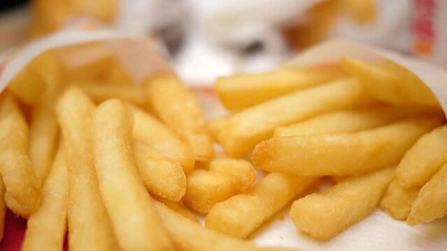 Closeup slow motion eating French fries fast food potatoes chips male fingers pick up a snack piece