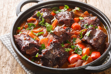 Estofado de Rabo de Toro Spanish Oxtail Stew closeup on a pot on the wooden table. Horizontal