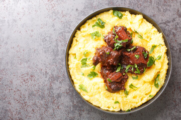 Rabada Oxtail Stew in Red Wine closeup on plate on the concrete table. Horizontal top view from above