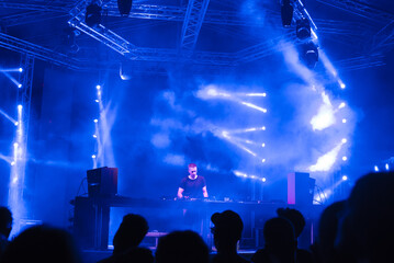 Dj playing techno music on the night concert in summer.