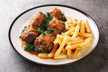 Oxtail in sauce Rabo de toro served with french fries on white plate on the concrete table. Spanish dish. Horizontal