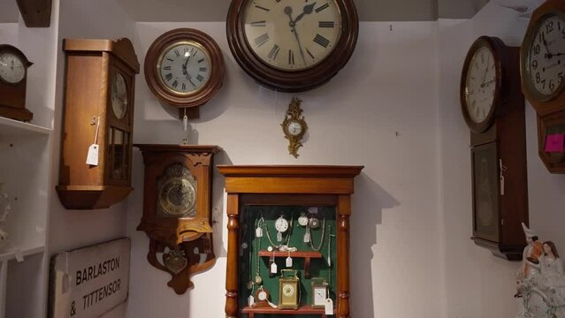 Push-in shot of clocks and stopwatches hanging in antique store