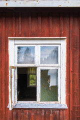 Fototapeta na wymiar Open window on an old deserted cottage