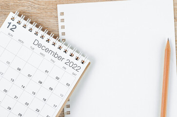 Fototapeta premium December 2022 desk calendar with blank paper sheet for your text or message on wooden background.