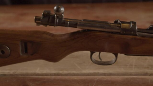 close Dolly of Kar98 Mauser rifle with an open bolt standing on a wooden surface