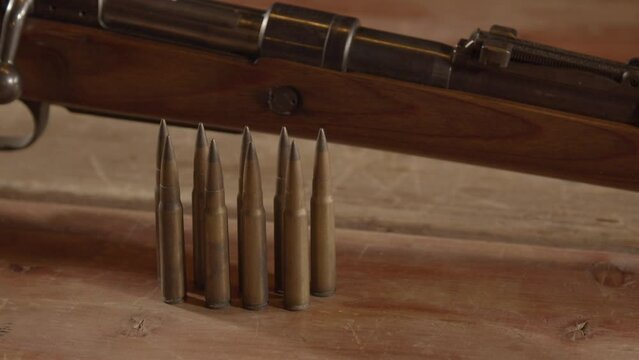 Close Dolly in of 8mm cartridges in front of WW2 era Mauser Kar98k