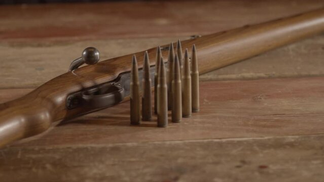 Old WW2 era Mauser K98 rifle with ammunition on a wooden surface
